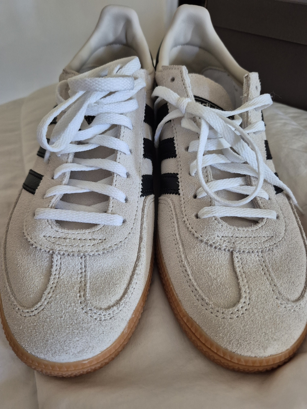 Classic UnisexSuede Sneakers in Off-White with Black Stripes.